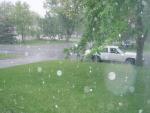 Rain coming down on our front yard & white car.