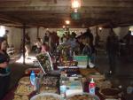the tables of food, and people talking to one another and loking at auction things.