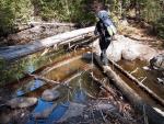 Heidi balances across stream between Horseshoe Lake and Lake Three.